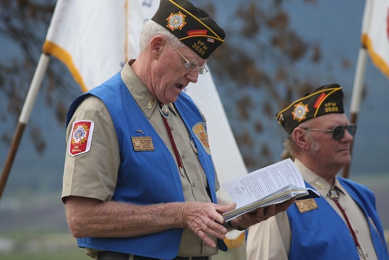 Jim Gillenbrand reads the Memorial Day speech at the Plains cemetery on Sunday evening.