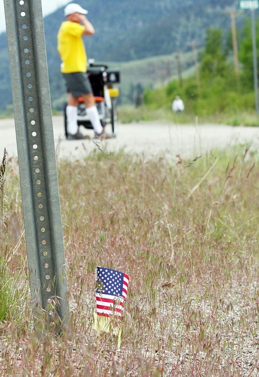 Small American flags with yellow ribbons tied around them are placed at mile markers across the U.S. as part of cross country runner Mike Ehredt's personal journey to honor the fallen soldiers in Iraq.
