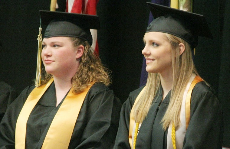 Susan Martin, left, and Heather Pruitt, right prepare to receive their high school diploma.