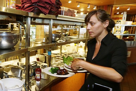 &lt;p&gt;Wendy Harrison, a waitress at the icon Grill in Seattle, picks up a food order from the kitchen as she works during lunchtime Monday.&lt;/p&gt;