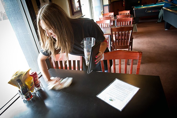 &lt;p&gt;Brittiany Hart clears a table at the Coeur d'Alene Brewing Company during her shift Friday. Hart underwent nearly $30,000 of medical care after a run-in with a bobby pin in April that caused an infection which prompted an emergency surgery to save her arm and required intravenous antibiotics.&lt;/p&gt;