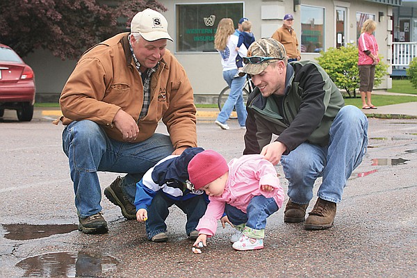 Little guys Landon Ludwick and Isabella Allred bump heads while picking up candy during Polson's Memorial Day parade.