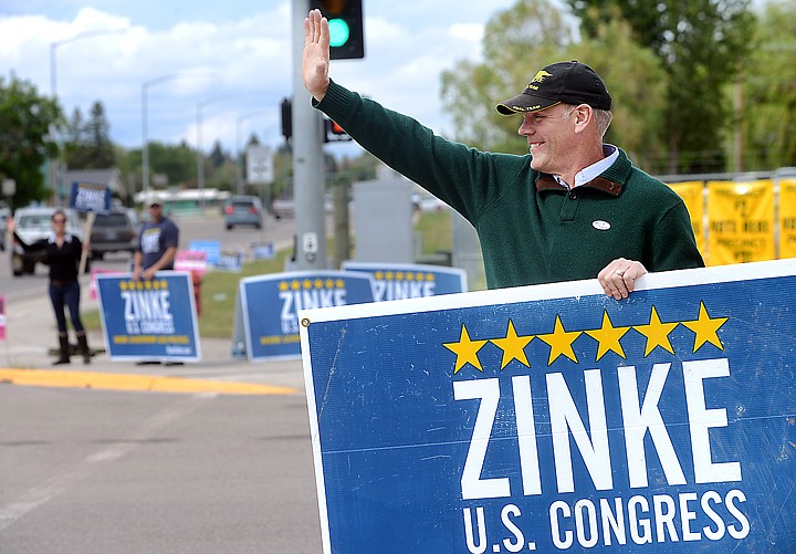 <p>House GOP candidate Ryan Zinke waves to passing cars and voters outside the Flathead County Fairgrounds on Tuesday in Kalispell. (Brenda Ahearn/Daily Inter Lake)</p>