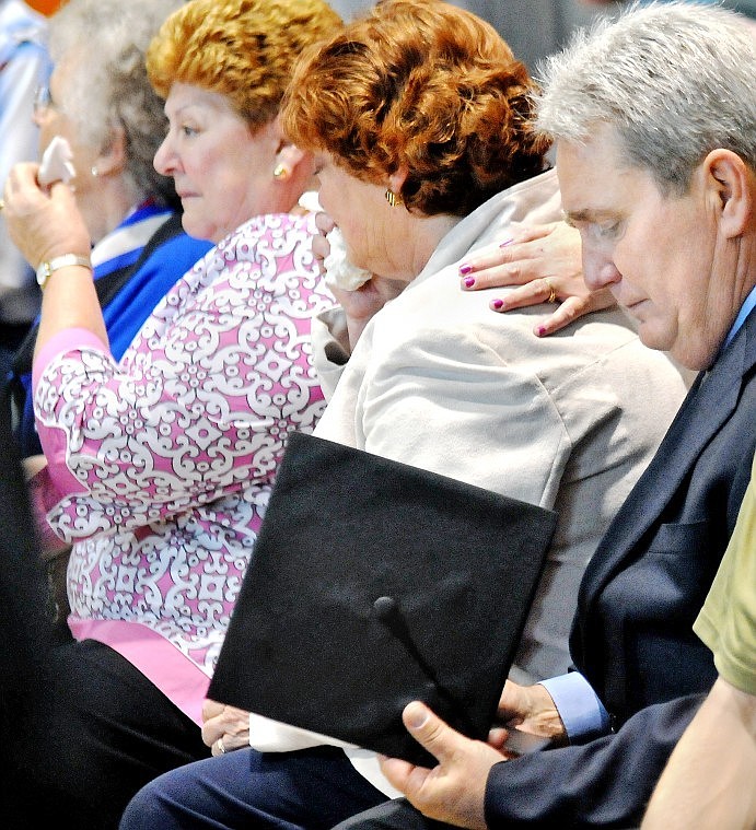 Scott Hineman, father of Ian Hineman, looks down at a graduation cap after being given the cap and a honorary Flathead High School diploma for his son Ian, who passed away in late 2008 from an accidental carbon monoxide poisoning.