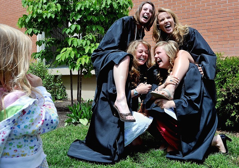 From left, Flathead High Graduates Abbie Foley, Ilene Terry, Caitlin Brown, and Tiffany Habel pose for a pictures taken by friends while Addison Blumenshine, 3, at right, looks on.