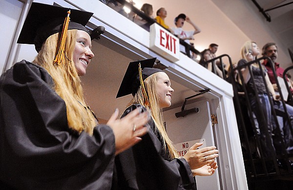 Alex Bardwell, left, and Rindi Beagley applaud as the seniors at Flathead High School prepare to proceed into the gymnasium for this year&#146;s commencement ceremony Saturday afternoon in Kalispell.