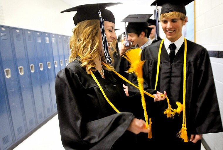 Stillwater Christian Graduating Senior Amy Carlin twirls her tassels while her twin brother Brad (right) looks on in the hallway before the start of the school's 24th Commencement Ceremony Friday evening.