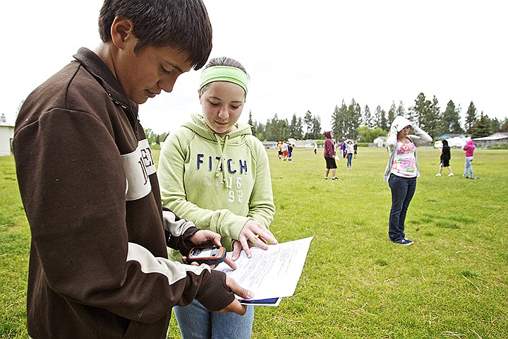 &lt;p&gt;JEROME A. POLLOS/Press Giovanni Parras, 12, and Laura Cameron, 13, read through their teacher's instructions to finding the area and perimeter of various geometric shapes using data obtained from a handheld GPS device during a class exercise Thursday at Post Falls Middle School.&lt;/p&gt;