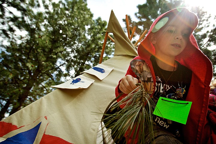 Andrew Wallace exits a teepee after inspecting the interior Wednesday at the Idaho History Outdoor Museum created by University of Idaho education students and Seltice Elementary students. The museum showcased a miners' tent, a short pathway and historical information regarding the Oregon Trail, a frontier general store, gold mining operation and an example of a Native American encampment.