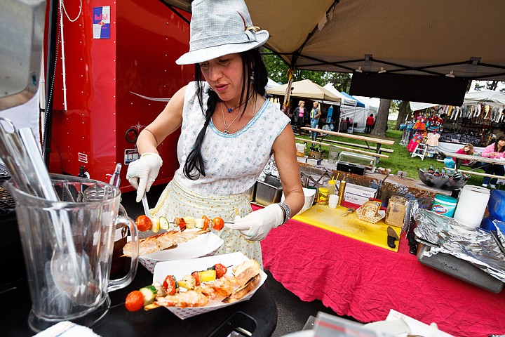 Laura Calvert, co-owner of Jupiter Jane Traveling Cafe, prepares and order of skewered shrimp and vegetables Friday as Post Falls Days kicks off at Q'emiln Park.  Festivities will continue through the weekend, until 4:00 p.m. Sunday.