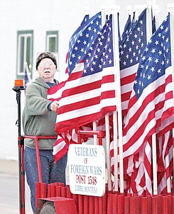&lt;p&gt;Chuck Baker rides the &quot;flag trailer&quot; early Monday morning placing flags into their standards along Mineral and California Avenues.&lt;/p&gt;