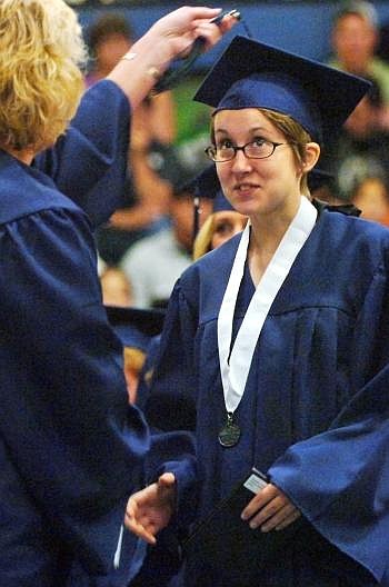 School board chairwoman Anna Marie Bailey moves Eve Haegele's tassel after she received her diploma Saturday at Glacier High School's graduation ceremony the first in the history of the Kalispell school. Nate Chute/Daily Inter Lake