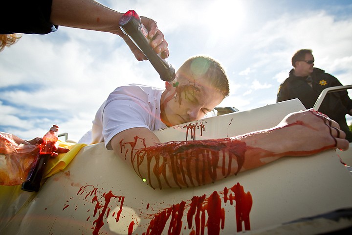 &lt;p&gt;JEROME A. POLLOS/Press Connor White has fake blood poured onto his head an arm as Kootenai County Sheriff Deputy Jack McAvoy helps prepare the scene Thursday for a mock alcohol-related crash for students at Coeur d'Alene High School. The program's was held to demonstrate the realities and consequences of drunk driving. Multiple law enforcement agencies, the Coeur d'Alene Fire Department and a MedEvac helicopter took part in the effort.&lt;/p&gt;