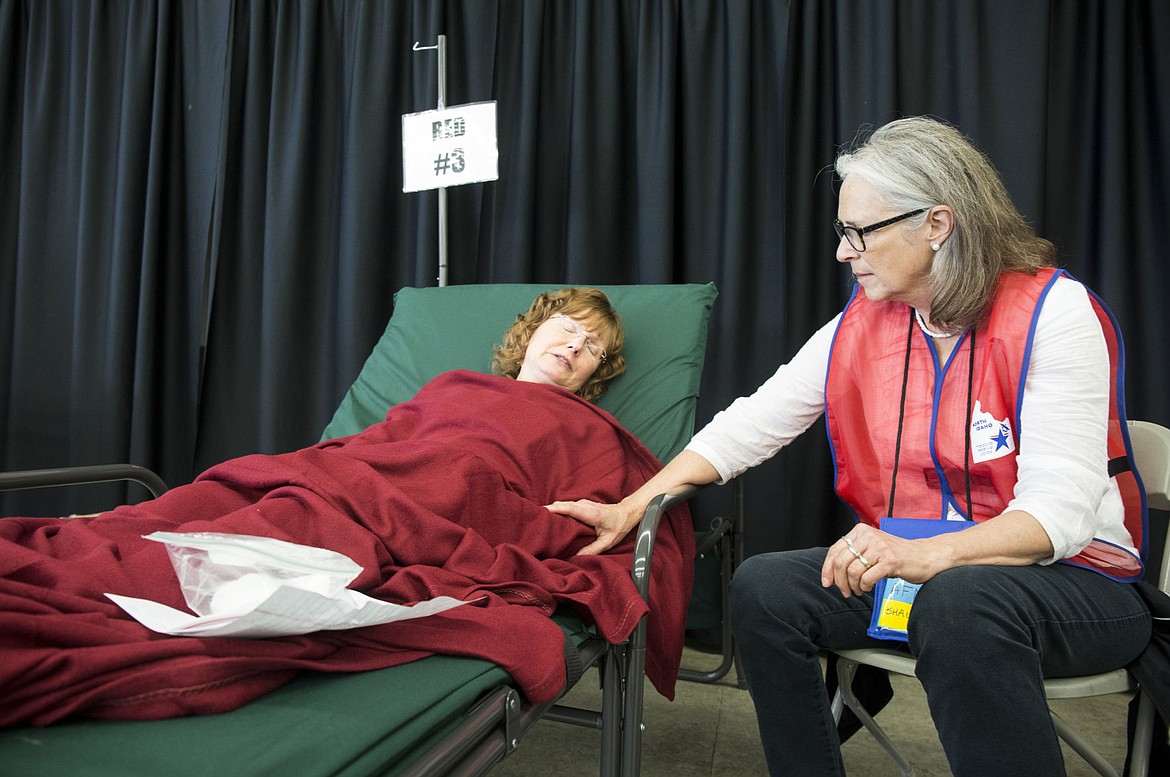 &lt;p&gt;Volunteer Shauna Miller, right, of the Medical Reserve Corps, comforts Audrey Hammons, a Seattle resident, at her bed inside one of the medical needs shelters set up at the fairgrounds on Thursday for evacuees of the fictional tsunami and earthquake disaster which devastated the West Coast.&lt;/p&gt;