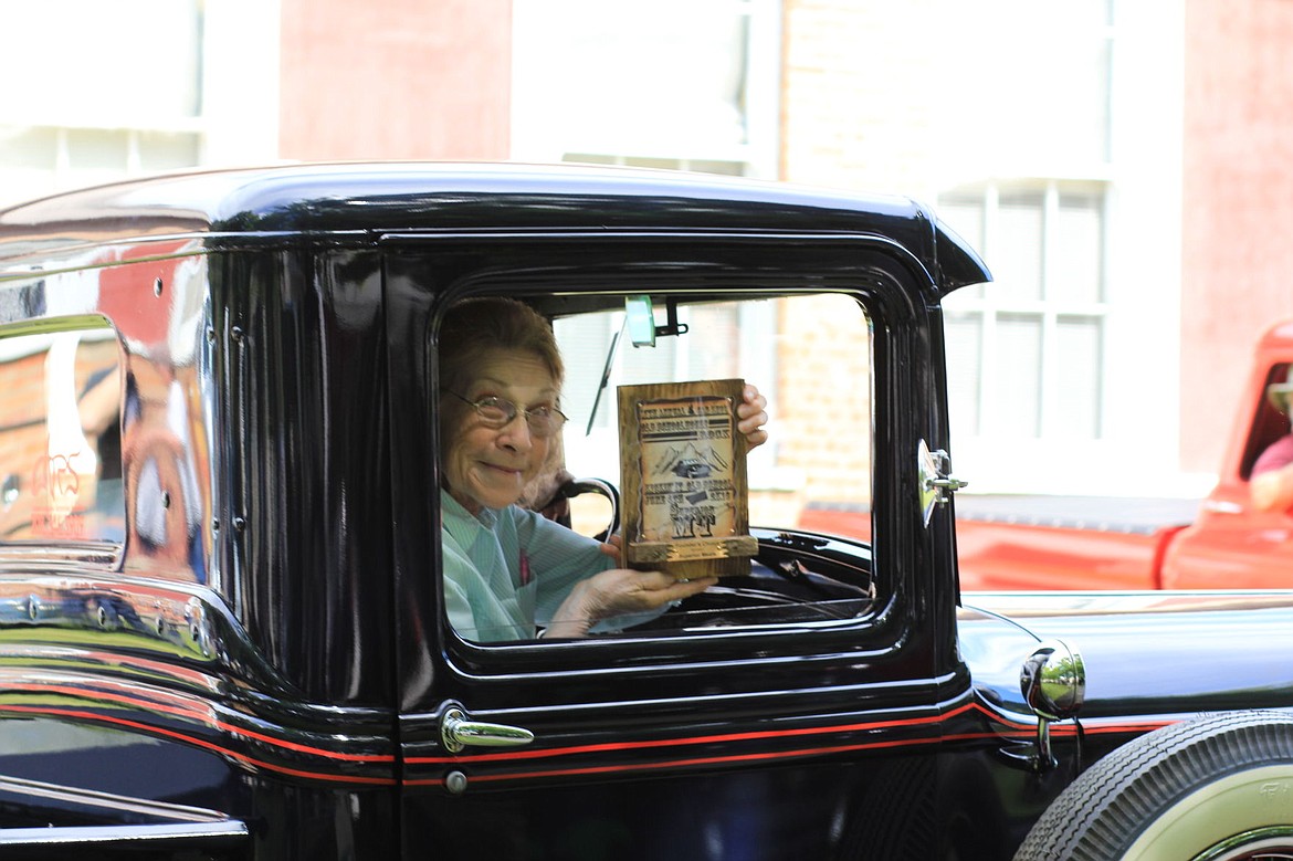 <p>Tressie Fink of Superior, shows off the award won with her husband, Fred, for Founder's Choice. The award was presented by car show founder, Gordon Hendrick earlier in the day.</p>