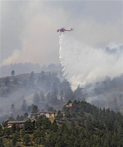 &lt;p&gt;A helicopter drops water on trees burning behind homes on the High Park wildfire near Fort Collins, Colo., on Monday, June 11, 2012. The wildfire is burning out of control in northern Colorado, while an unchecked blaze choked a small community in southern New Mexico as authorities in both regions battled fires Monday. (AP Photo/Ed Andrieski)&lt;/p&gt;