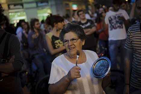 &lt;p&gt;A demonstrator hits a pot during a protest against the financial crisis and the latest government Economic measures in Sol square,in Madrid Sunday June 10, 2012. Spain's grinding financial misery will get worse this year despite the country's request for a European financial lifeline of up to a euro100 billion euros ($125 billion) to save its banks, Prime Minister Mariano Rajoy said Sunday, a big blow to a nation that took pride as the continent's economic superstar just a few years ago only to see it become the hot spot in the eurozone debt crisis. A day after conceding Spain needed outside help after months of denying it would seek assistance, Rajoy said more Spaniards will lose their jobs in a country where one out of every four are unemployed as the country becomes the fourth and largest of the 17 countries that use Europe's common currency to request a bailout. (AP Photo/Daniel Ochoa de Olza)&lt;/p&gt;