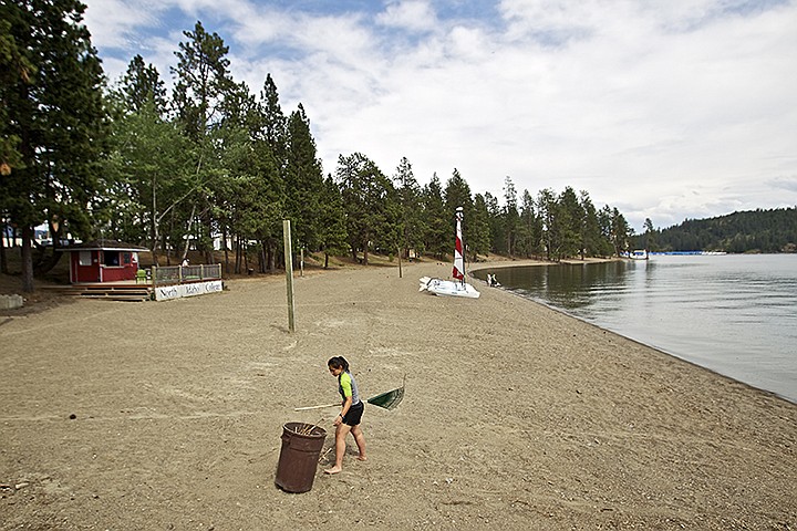 &lt;p&gt;JEROME A. POLLOS/Press Kris Belessis, a summer intern from Vermont with North Idaho College's Outdoor Pursuits, rakes debris from the beach area Monday in preparation for summer activities.&lt;/p&gt;