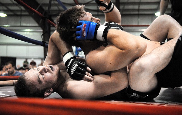 Will Barnhart of Kalispell, bottom, wrestles with Jarod Milko of Canada during the first round of their championship bout on Friday at the Kalispell Combat event.