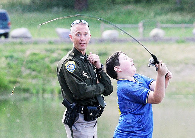 &lt;p&gt;Montana Highway Patrolman John Underwood helps Bailey Hylton as he cast during the Cops and Bobbers event at Pine Grove Pond on Wednesday. (Aaric Bryan/Daily Inter Lake)&lt;/p&gt;