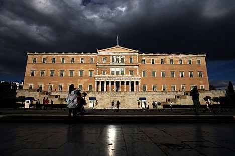 &lt;p&gt;People walk outside the Greek parliament on May 15. Bankers, governments and investors are starting to prepare for Greece to drop the euro currency, a move that could spread turmoil throughout the global financial system. Today's Greek election will go a long way toward determining whether it happens.&lt;/p&gt;