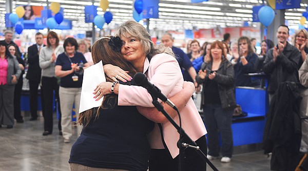 Walmart store manager Julie Keyes right, gives a hug to employee Elizabeth Gadilauskas after the singing of the National Anthem at the opening of the new store in Kalispell.