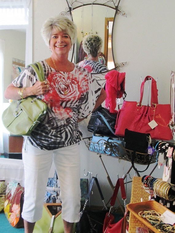 New sales assistant Kay Patterson models one of the ladies hand bags offered at The Island Boutique.