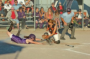 The Polson Purple Rain's Riley Kenny tries to find home plate through the dust as the 16U Ronan Raptors' Lindsay Clairmont tries to apply the tag.