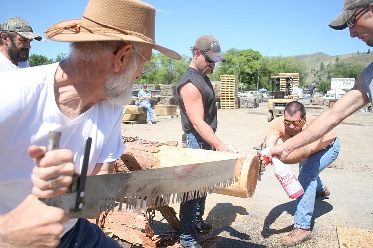 Alvie Marcellus of Spokane, left, works with DJ Auker of Plains work the saw with the cross cutting competition.