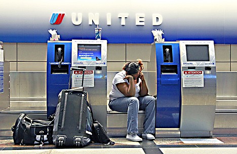 &lt;p&gt;United Airlines passenger Therell Churchill waiting at the United Airlines ticket counter at Denver International Airport Friday.&lt;/p&gt;