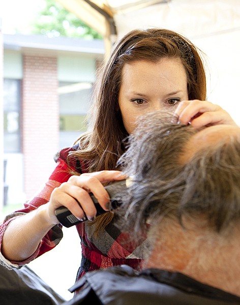 As part of Project Homeless Connect, Saretta Eash, a volunteer from Soucie &amp; Soucie Hair Design salon, gave free haircuts outside the Samaritan House Administration Building Thursday afternoon.