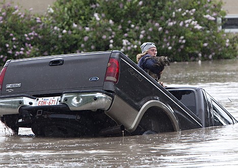 &lt;p&gt;Kevan Yaets crawls out the back window of his pick up truck with his cat Momo as the flood waters sweep him downstream after submerging his truck in High River, Alberta on Thursday.&lt;/p&gt;