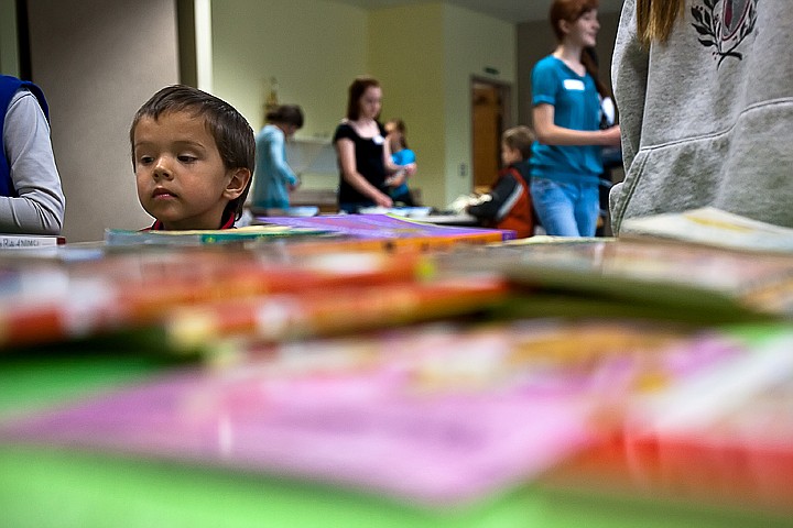 &lt;p&gt;BEN BREWER/Press Drew Zeller pokes his head over a table full of books during the Make a Splash at Your Library reading promotion at the Post Falls Public Library. Zeller was able to receive a free book on Wednesday by signing up for the library's summer reading program and receiving his reading log to be filled out for every book he finishes this summer.&lt;/p&gt;