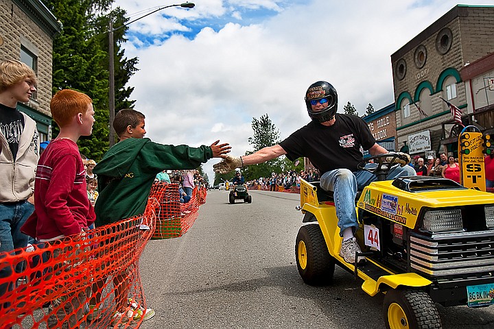 &lt;p&gt;Marc Kroetch, right, gives a drive-by high five to Stephen Loftis, left, on Kroetch's racing lawnmower &quot;Mow Heat Oh!&quot; during the Big Back-In on Maine Street in Spirit Lake. Kroetch along with several others began the annual Father's Day tradition of the Big Back-In in Spirit Lake ten years ago as a way to fundraise for city projects.&lt;/p&gt;