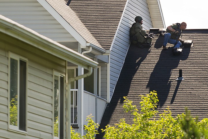 &lt;p&gt;Two officers hold a position on the roof adjacent to an apartment where a suspected gunman stands off police. (SHAWN GUST/Press)&lt;/p&gt;