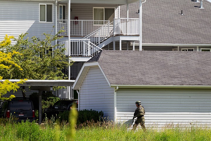 &lt;p&gt;Armed with an automatic rifle, a Coeur d'Alene Police Department SWAT team officer circles around a garage in front of the apartment of an male believed to armed with a rifle. (SHAWN GUST/Press)&lt;/p&gt;