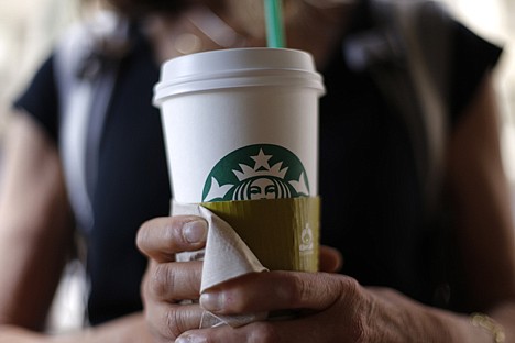 &lt;p&gt;A woman holds a coffee drink outside a Starbucks in downtown Chicago. Starbucks is raising prices on some of its drinks by 5 cents to 20 cents starting next week, and customers can also soon expect to pay $1 more for the packaged coffee it sells in supermarkets.&lt;/p&gt;