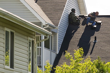 &lt;p&gt;Two officers hold a position on the roof adjacent to an apartment where a suspected gunman stands off police.&lt;/p&gt;