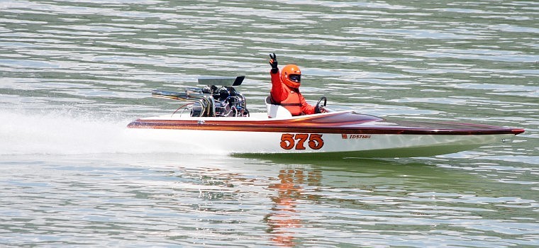 Doc Holiday flashes the peace sign to spectators on Saturday while he takes his boat around the course to put on a small show because the  races were cancelled due to debris in the water.