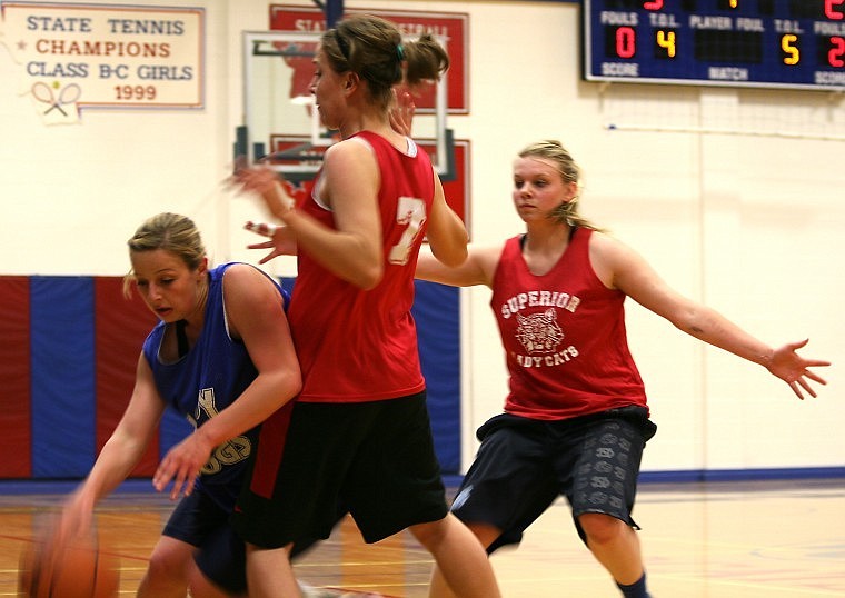 <p>Superior seniors Ashley Blaylock (center) and Malinda Steinebach
(right) trap a Mission Lady Dog Thursday night during a summer
league game against Mission.</p>