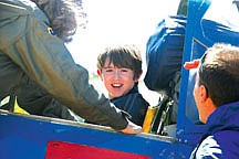 Alden Drew, 10, is all smiles after taking a spin in a vintage 1941 U.S. Army basic trainer airplane last Saturday. His dad Mark looks on while plane owner Linda Marshall helps Alden out of the aircraft.