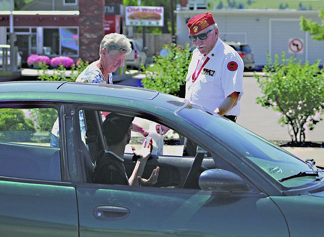 &lt;p&gt;Marion Woidtke, of Polson, makes a donation towards the Polson fireworks display Saturday while Marine veteran Mauri Morin tries to convince a driver to scramble for change. For more about July Fourth events see Community Calendar on C3.&lt;/p&gt;