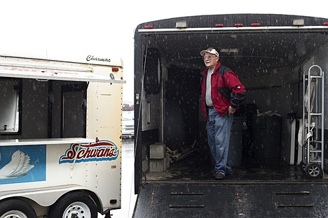 &lt;p&gt;Coeur d'Alene Elks Club member Bill Sawyer stands in the back of his trailer as rain pours down at the Coeur d'Alene airport Tuesday. Vendors and spectators gathered at the airport to watch World War II airplanes land. The aircraft were unable to take off from Seattle on both Monday and Tuesday due to poor weather conditions.&lt;/p&gt;