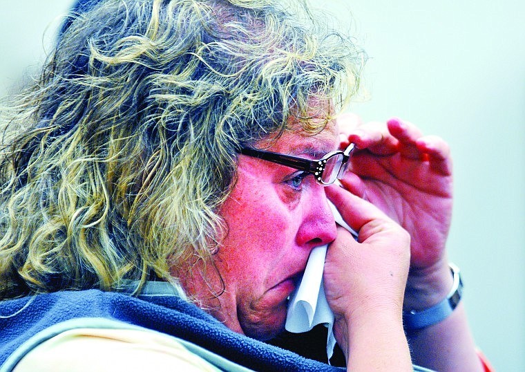 Teri Schneider, sister to Michele Miller. wipes tears away from her eyes while listening in Flathead County District Court during the trial of Baron James Foster, who is charged with Miller's homicide.