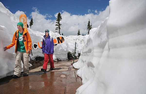 Bobby Syvertson of Glacier, left, and Daniella Rinehart of St. Mary, Mont. head up to the snow field at Logan Pass to do some snowboarding on Thursday. Yesterday was the first time Logan Pass was open to vehicles.