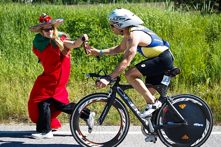 &lt;p&gt;SHAWN GUST/Press Angela Morelli, a volunteer at a bike aid station, hands off a performance drink to David Matheson dressed as a chili pepper.&lt;/p&gt;