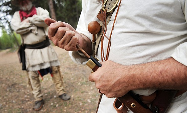 Brian Dinsmore of Eureka loads a pistol as David Swanson of Kalipsell, left, watches on Saturday at the Merical Mountain Rendezvous in Marion.