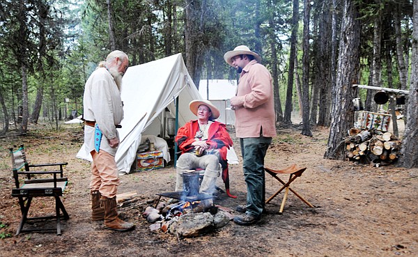 Allen Heiser of Marion, left to right, Ric Carter of Somers and John Wilson of Thompson Falls chat around the fire as Saturday evening begins to cool off at the Merical Mountain Rendezvous in Marion.