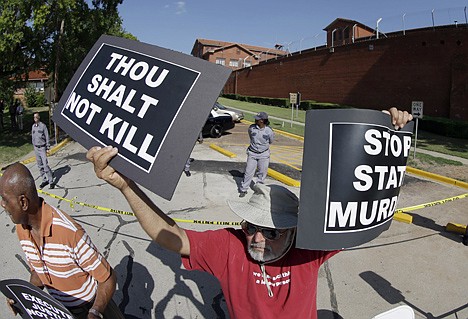 &lt;p&gt;Hadi Jawad holds up his signs to protest the execution of Kimberly McCarthy on Wednesday outside the Texas Department of Criminal Justice Huntsville Unit, where the death chamber is located, in Huntsville, Texas.&lt;/p&gt;