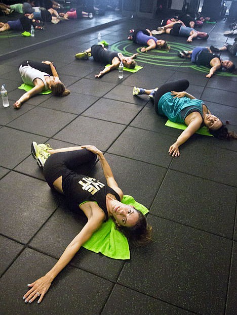 <p>Gym owner Kari Saitowitz, bottom, cools down with stretching exercises with a class after a workout at the Fhitting Room boutique fitness studio, Tuesday, in New York.</p>